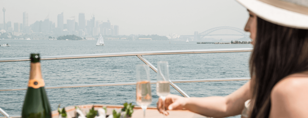 girl overlooking harbour with a glass of champagne