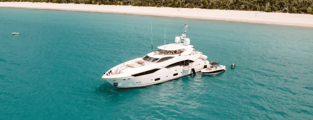 white yacht anchored beautiful beach